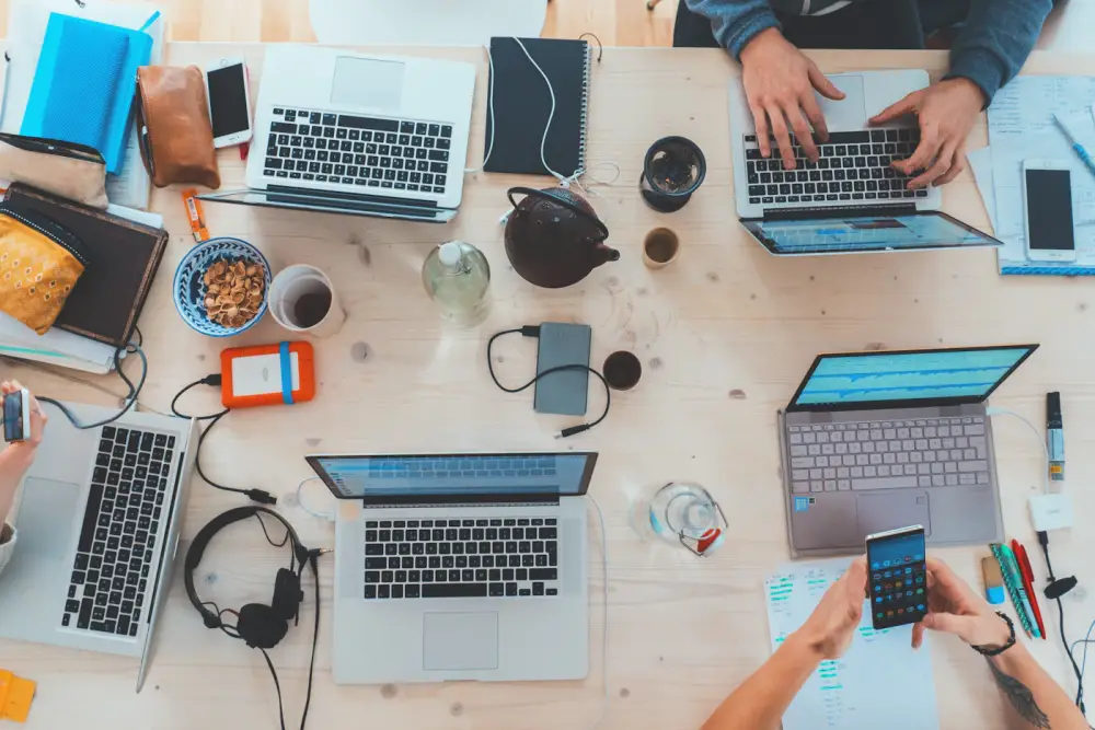Scrivania vista dall'alto con telefoni, tablet e taccuini usati per le prove